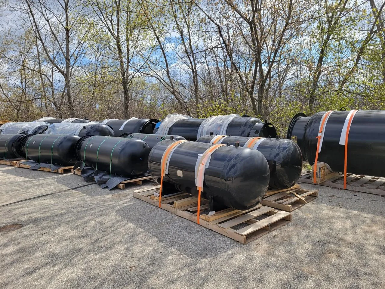 Multiple large nitrogen tanks on wood pallets outside